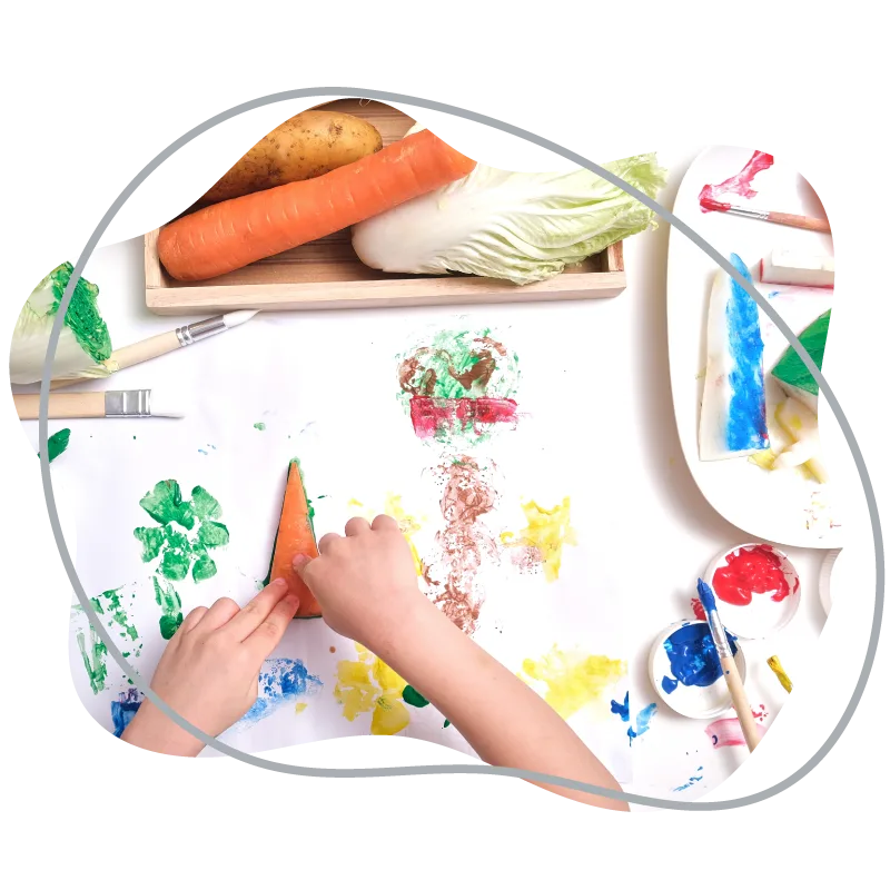 A child making vegetable-print paintings